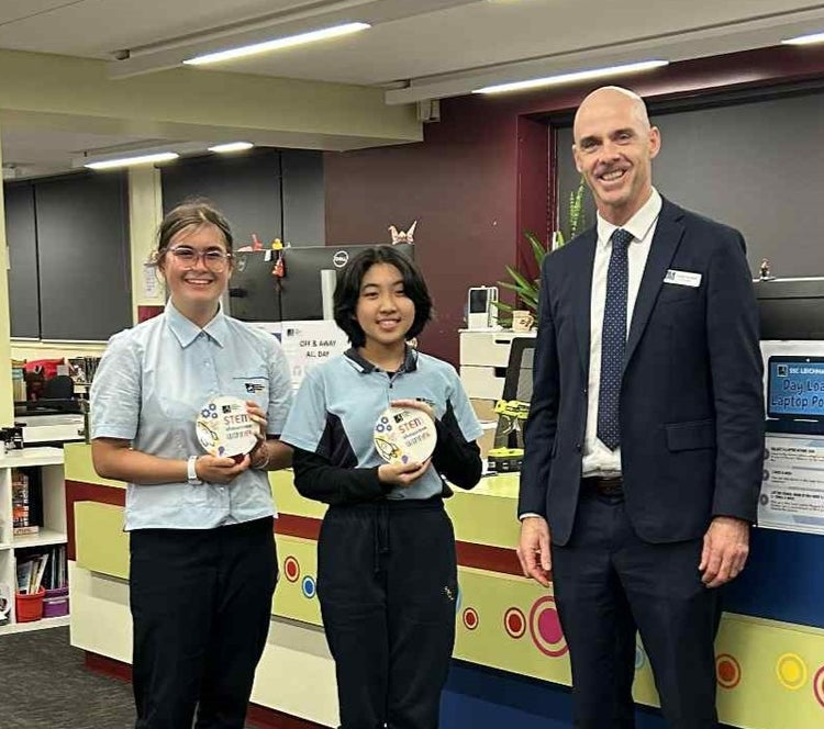 Two students with awards and principal Craig Marland