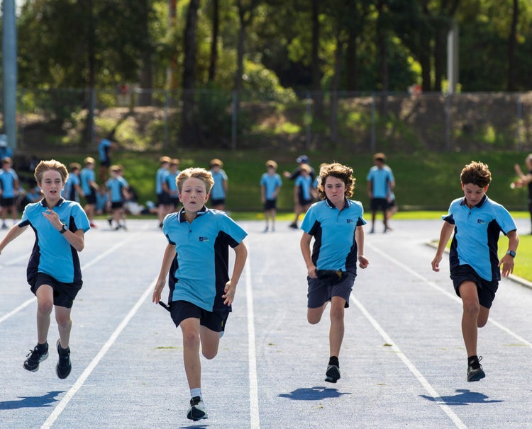 Four students racing at an athletics carnival
