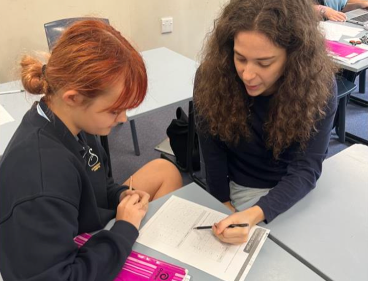 A learning support officer assists a student in the classroom