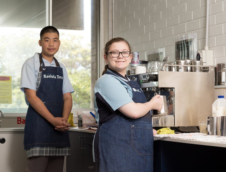 Two students learn to use a coffee machine
