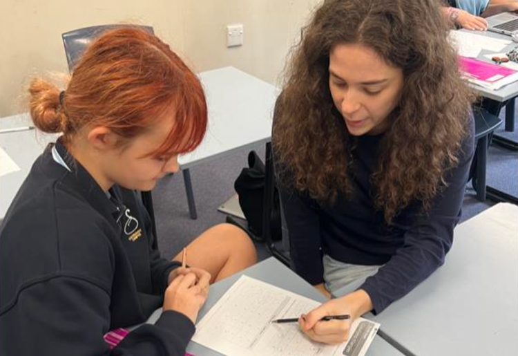 A student support office helps a student during class