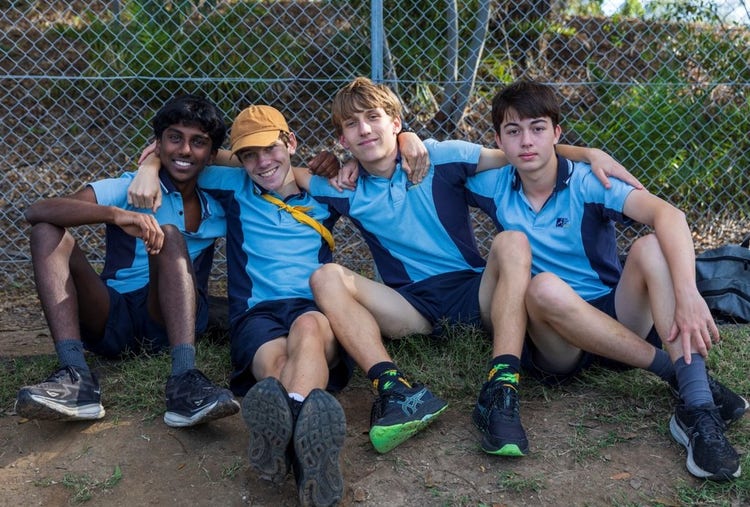 Four boys sitting together and smiling